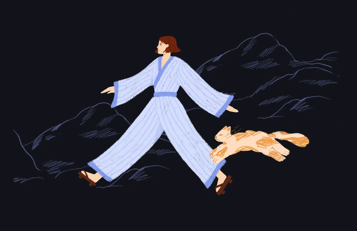 Woman in a striped robe striding through dark hills, a ginger cat leaping beside her